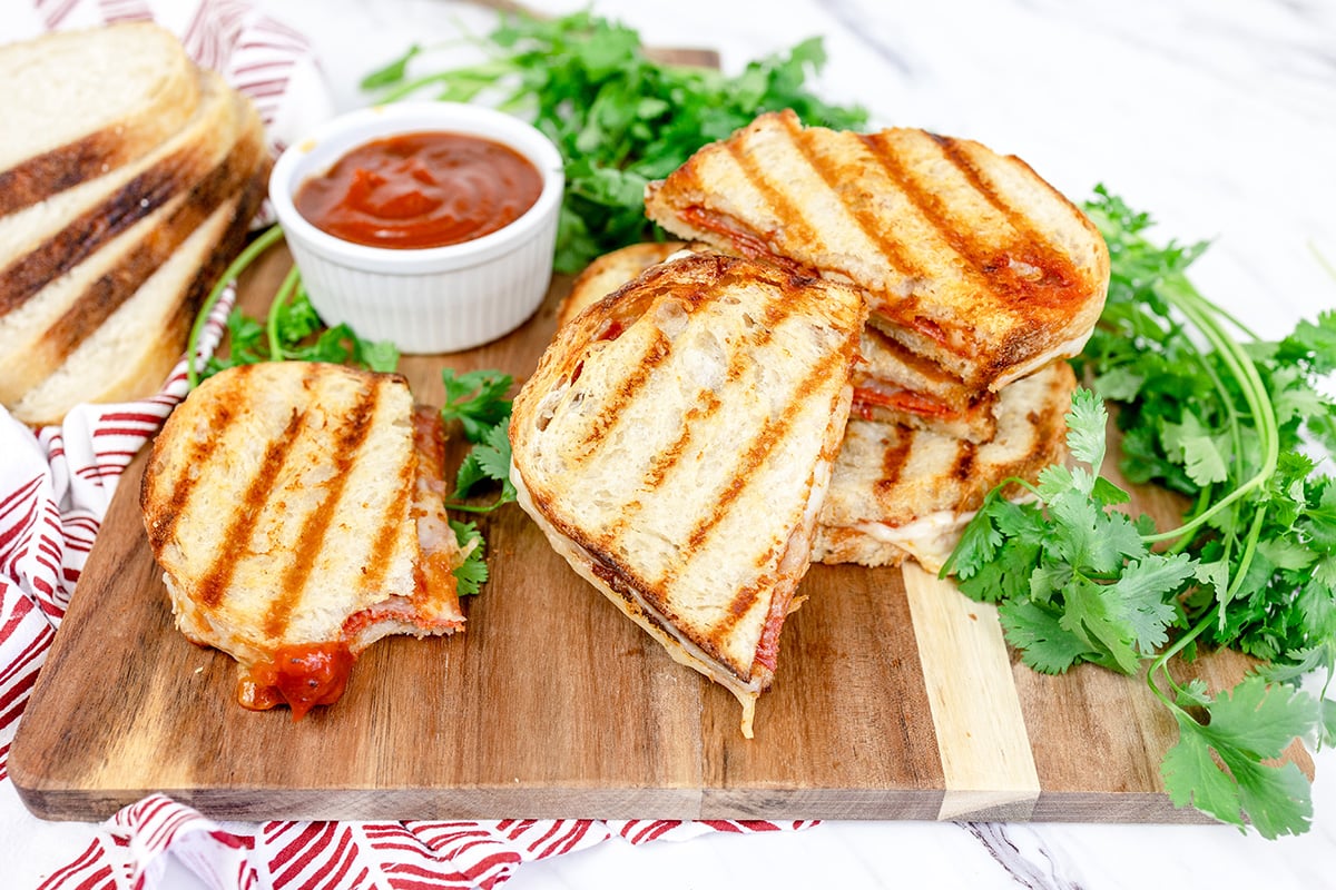straight on shot of pizza sandwiches sliced on a cutting board