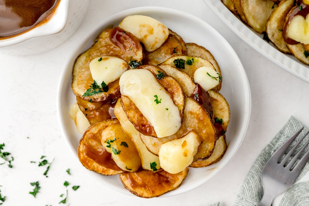 poutine on a small, white serving plate 