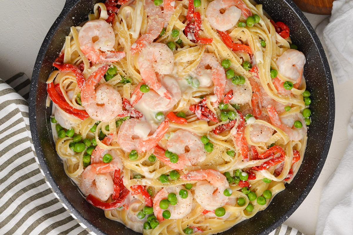 close up of alfredo with shrimp in a cooking vessel 