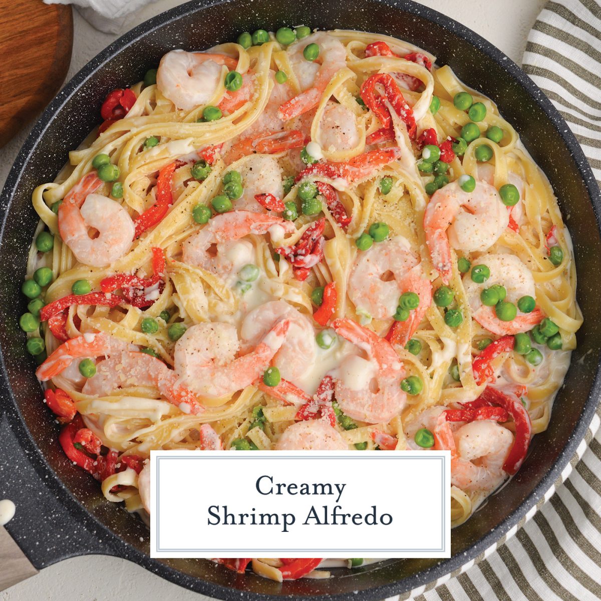 overhead of shrimp alfredo recipe in a skillet with text overlay