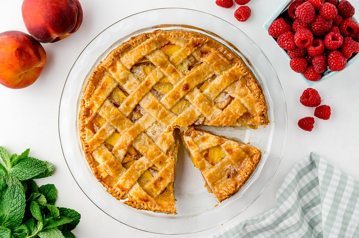 overhead shot of peach pie with slice taken out