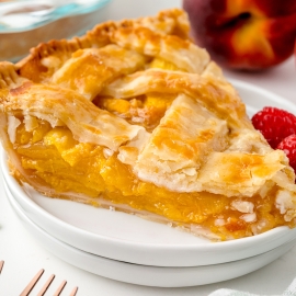 angled shot of slice of peach pie
