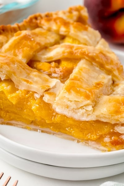 angled shot of slice of peach pie