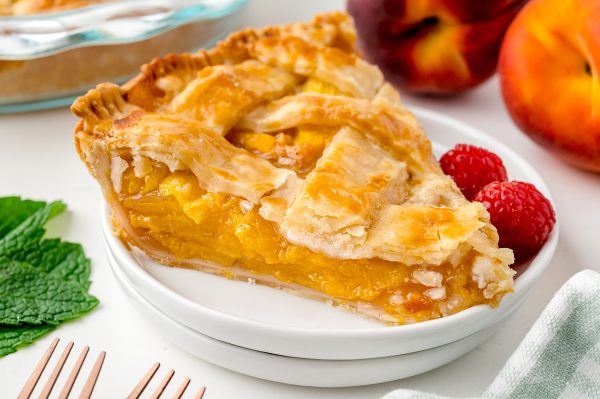 angled shot of slice of peach pie