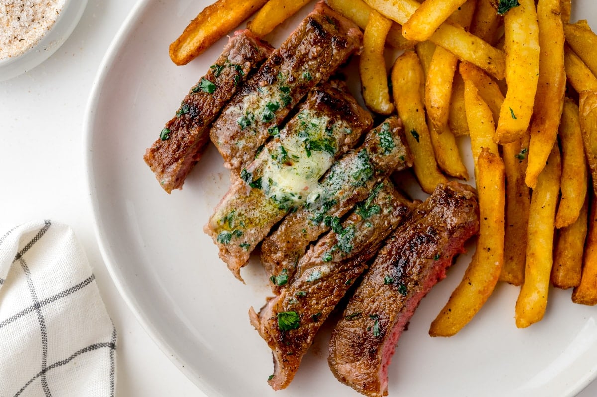 sliced steak frite recipe with flavored butter and fries