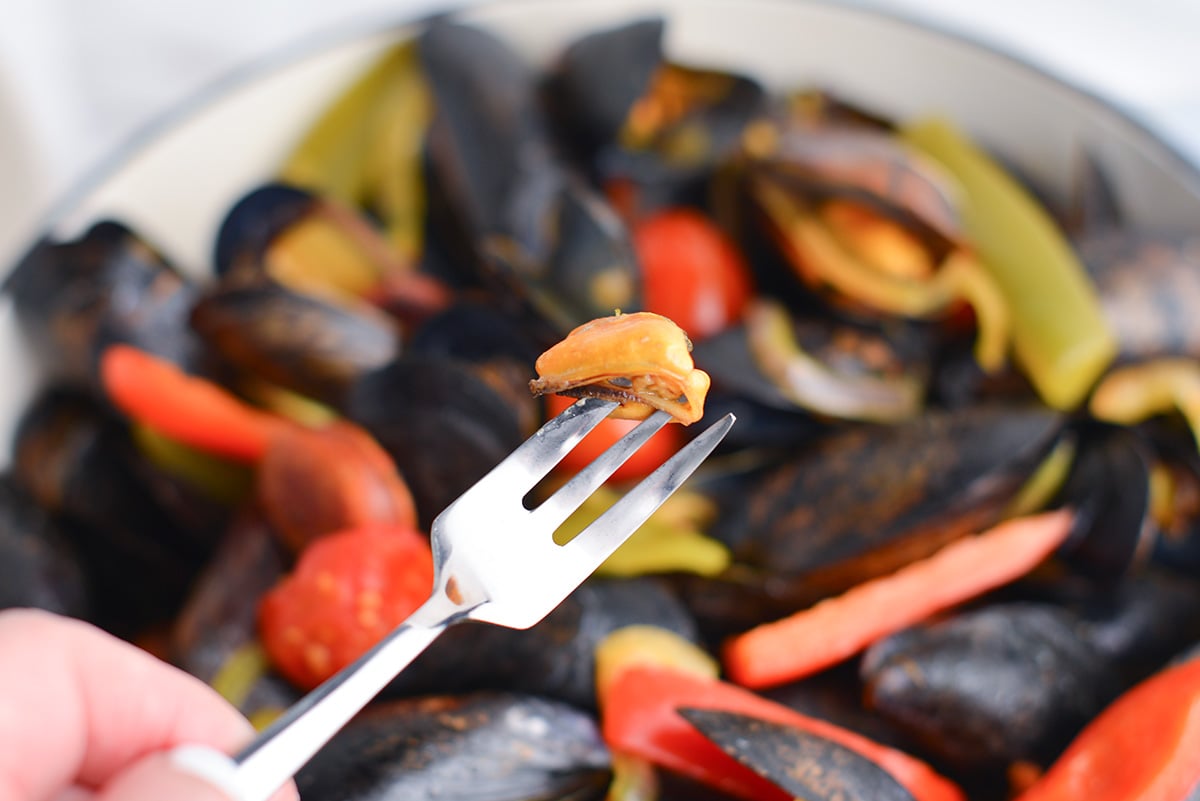 cooked mussel on a small fork 