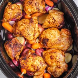 overhead shot of chicken thighs in slow cooker