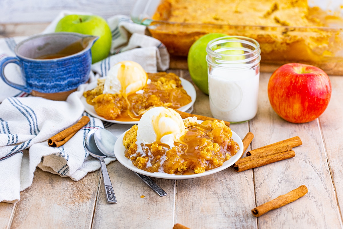 two dishes of caramel apple cake on white serving plates