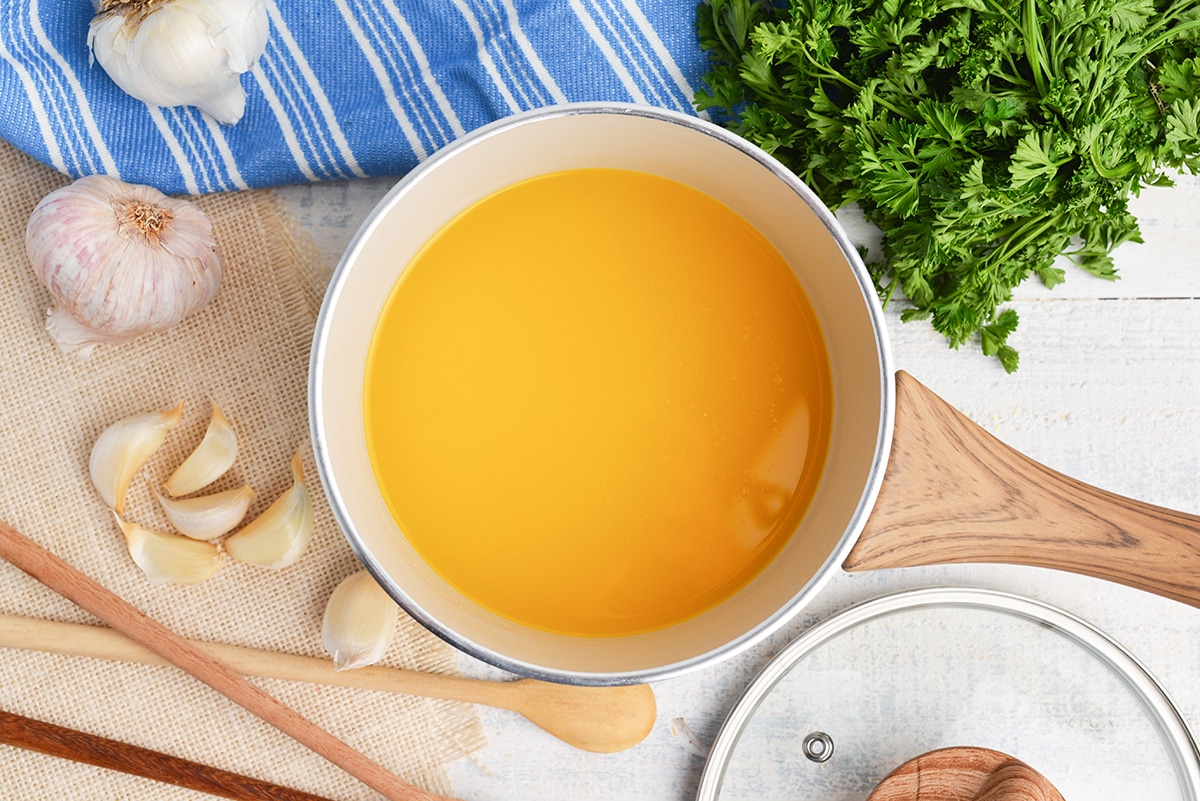 overhead of clarified butter in a white saucepan