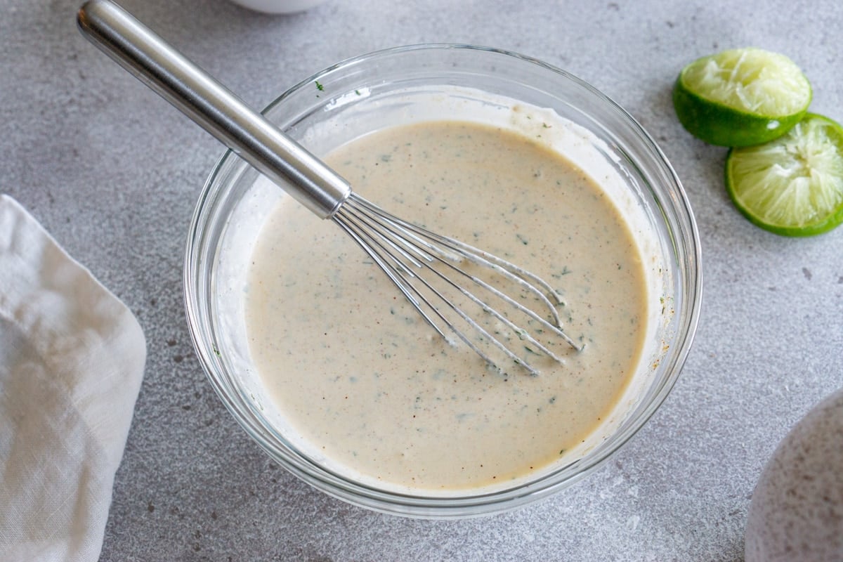 bowl of fish taco sauce with a whisk