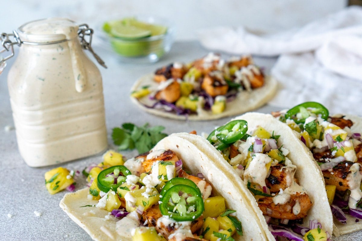 fish taco sauce in a jar with fish tacos