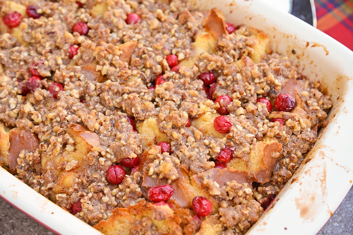 angle view of french toast bake in a casserole dish with cranberries and pecans