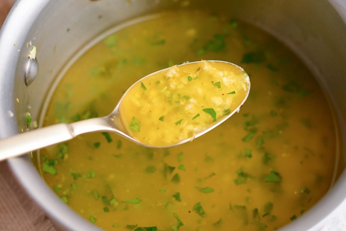 gold spoon with garlic butter sauce