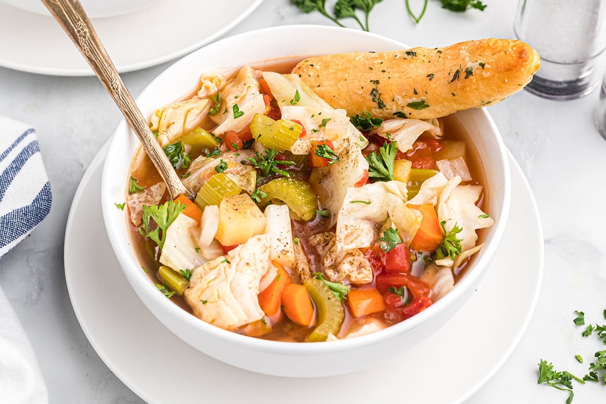 bowl of cabbage soup with breadstick