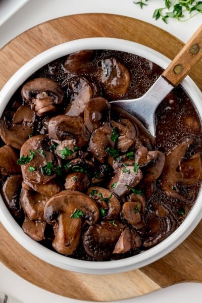 overhead of a spoon in a bowl of mushrooms