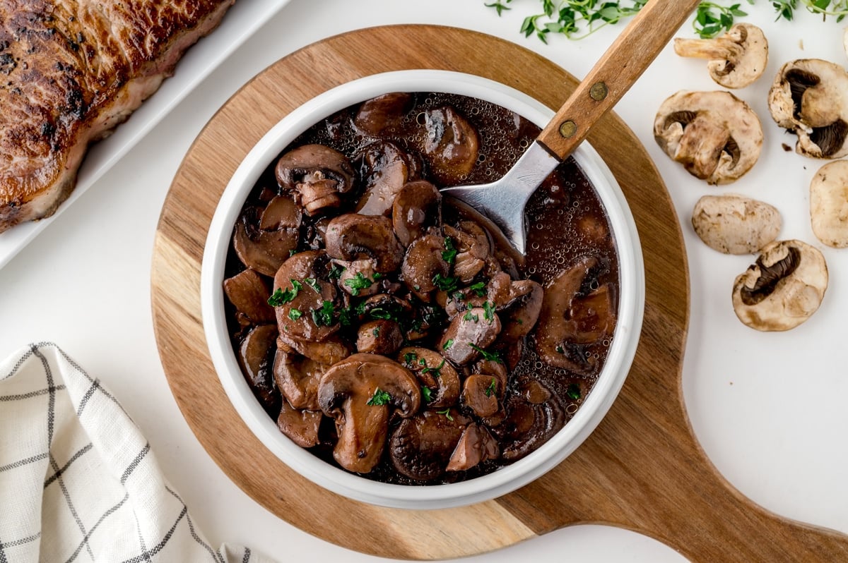 overhead of a spoon in a bowl of mushrooms