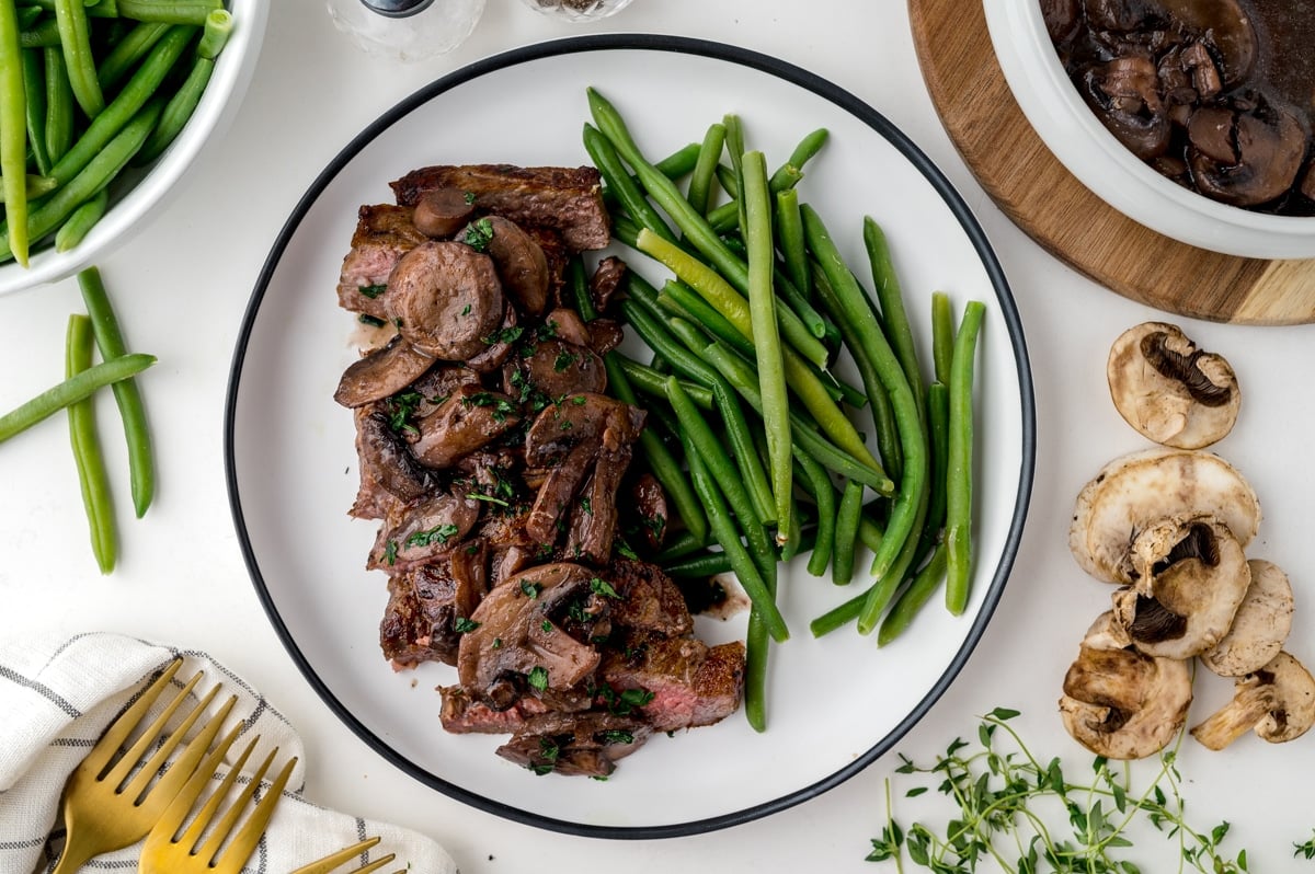 mushroom sauce over steak with green beans
