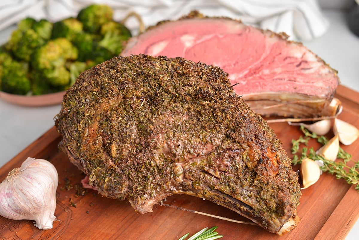 two bone rib roast cut in half on a wood cutting board