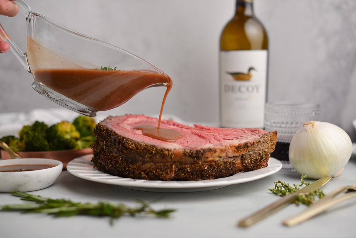 au jus pouring over a cut of prime rib