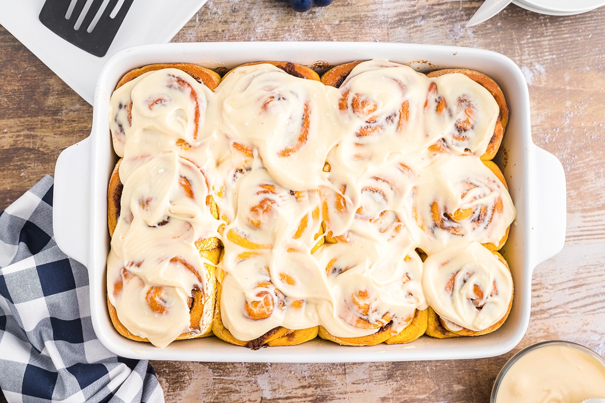 overhead tray of pumpkin cinnamons rolls with cream cheese frosting