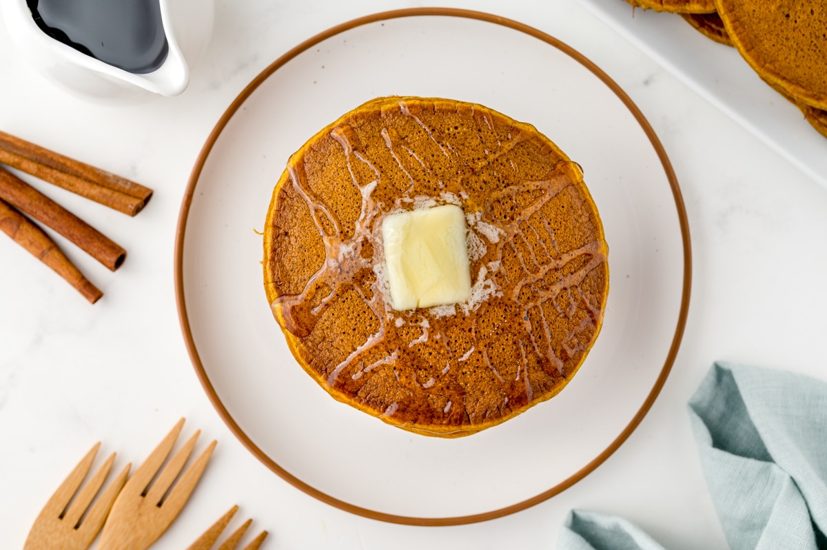 overhead pile of pancakes with butter and syrup