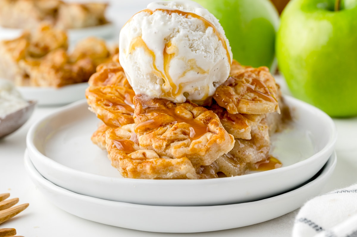 straight on shot of slice of apple pie topped with ice cream