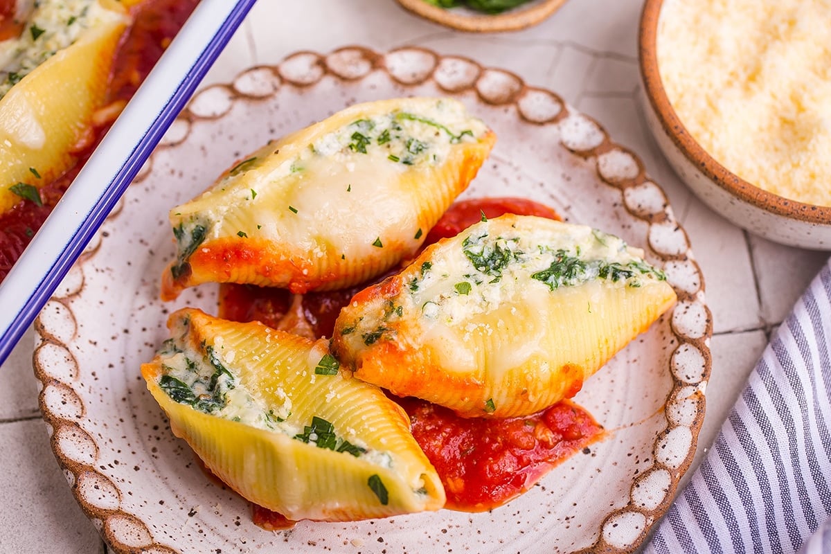 three stuffed shells on a white plate