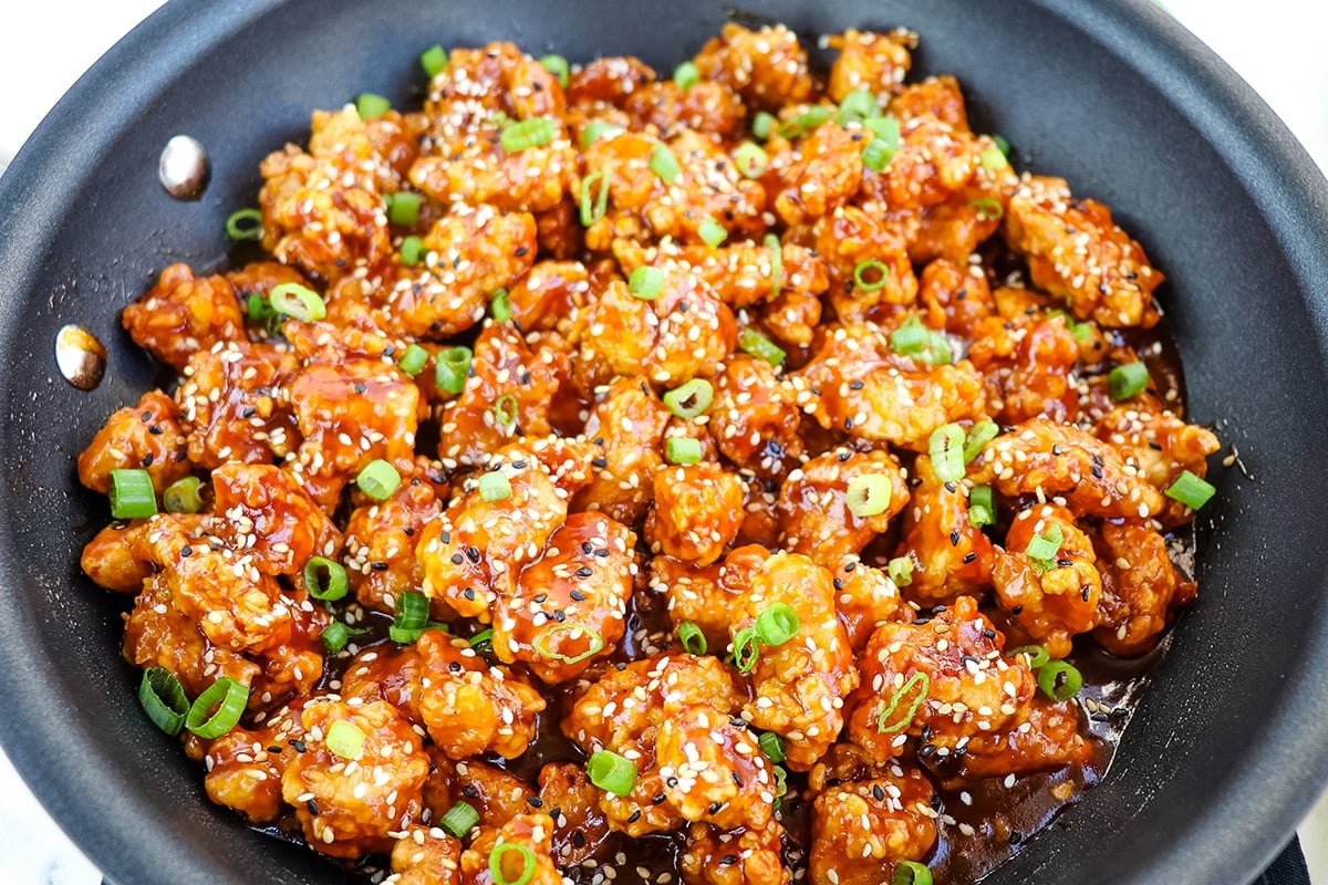 angled shot of sesame chicken in a pan