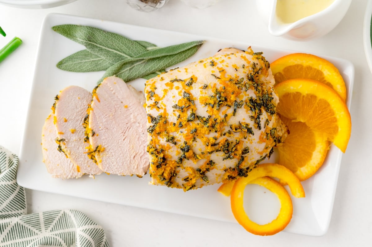 turkey breast sliced on a tray with orange slices