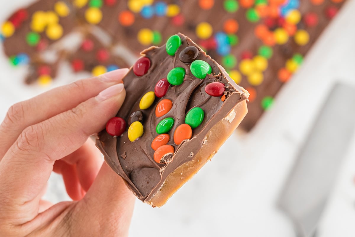 hand holding piece of candy toffee