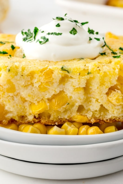 straight on shot of creamed corn casserole topped with sour cream