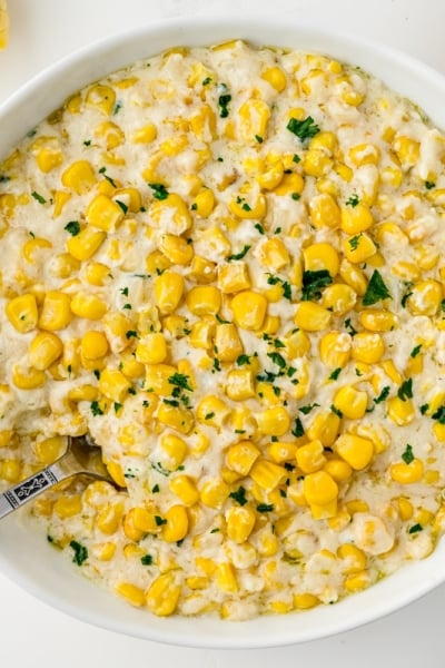 home style creamed corn in a bowl with parsley garnish