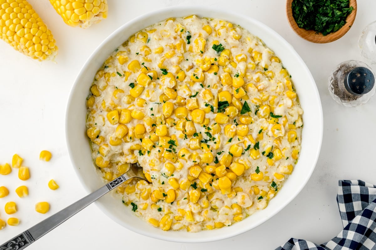 home style creamed corn in a bowl with parsley garnish