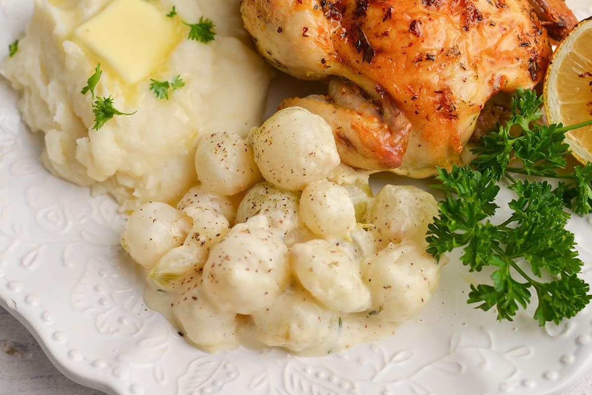 serving of creamed onions on plate with chicken