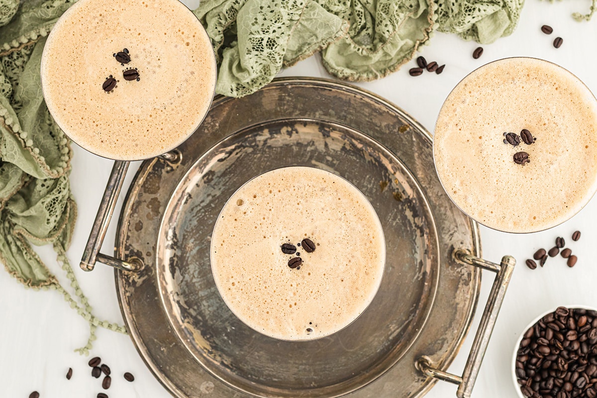 overhead shot of three espresso martinis on an old metal tray 