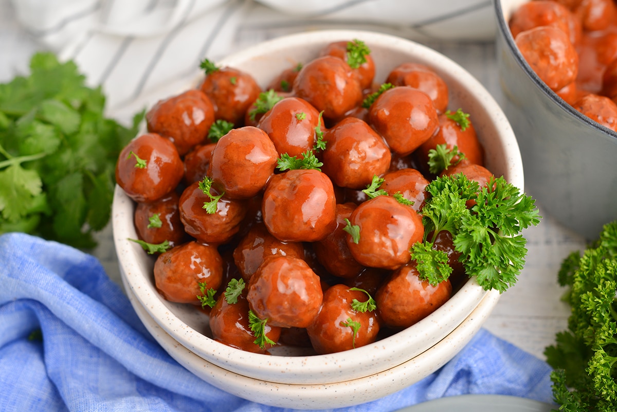 angle close up of grape jelly meatballs with parsley