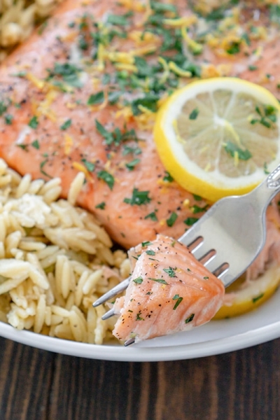 fork holding a bite of lemon pepper salmon