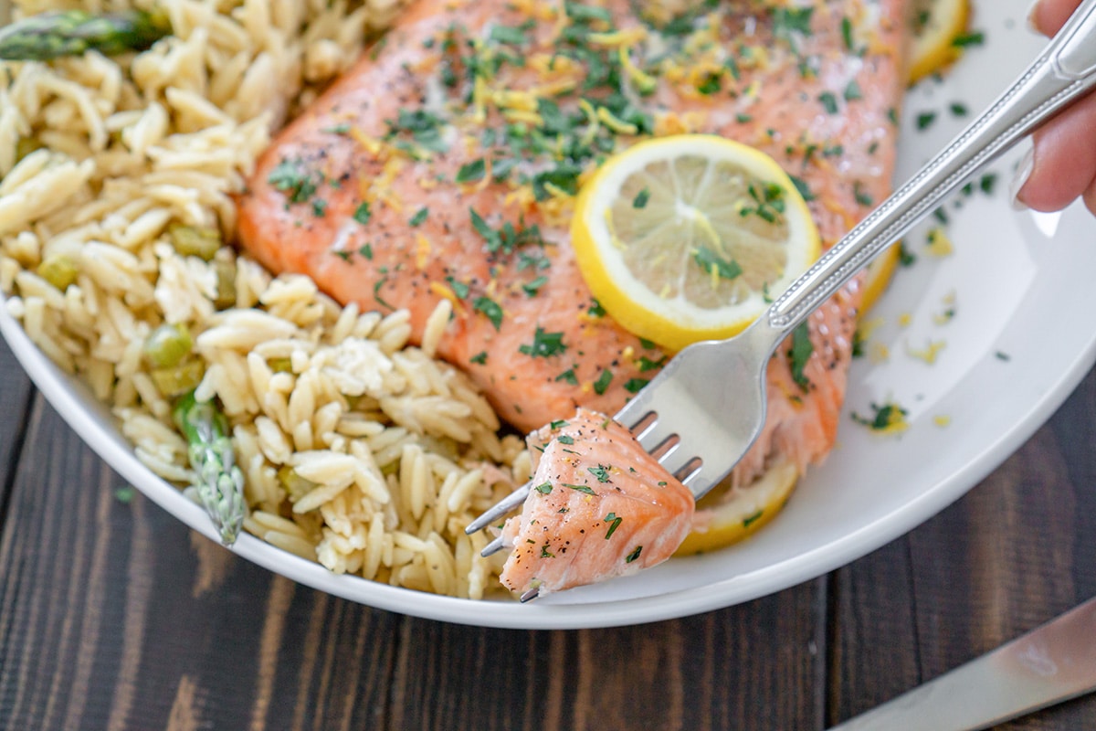 fork holding a bite of lemon pepper salmon