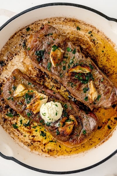 overhead of two steaks in a pan