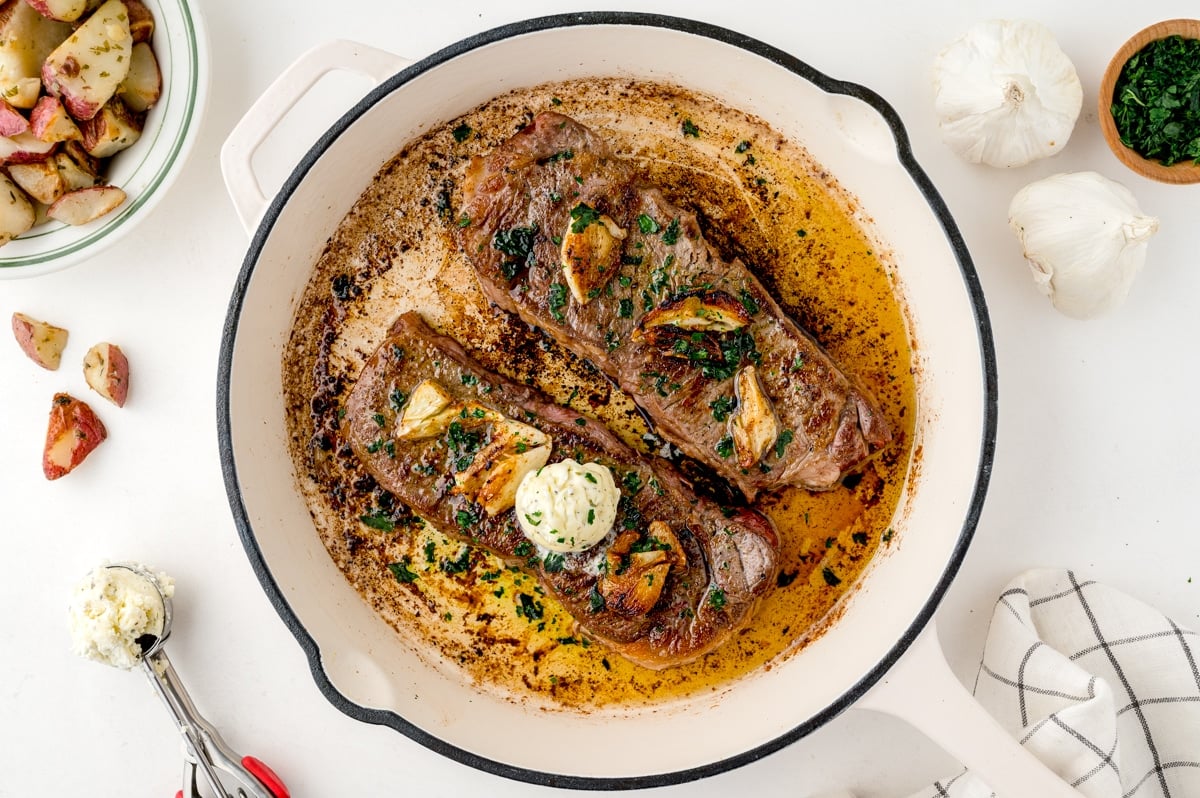 overhead of two steaks in a pan