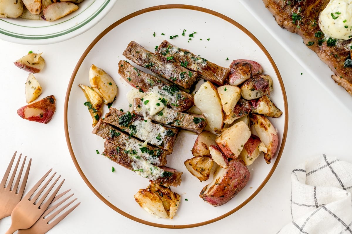 steak and potatoes on a white serving dish