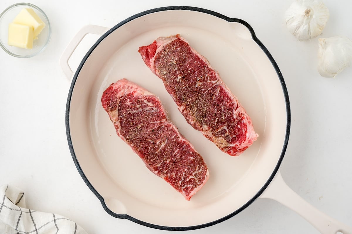 seasoned steaks in a cast iron skillet