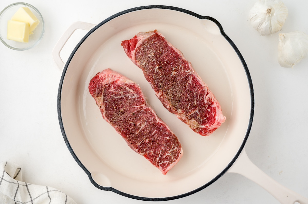 seasoned steaks in a cast iron skillet