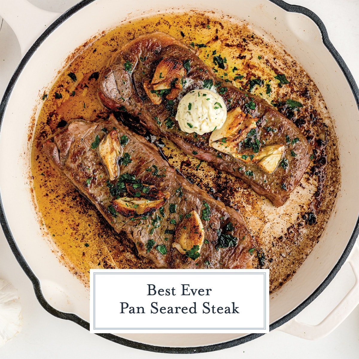 two strip steaks in a cast iron pan with butter