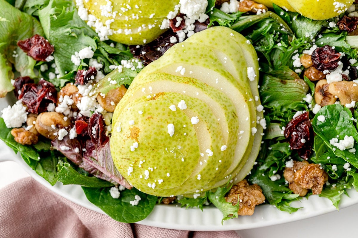 close up of sliced pear on greens