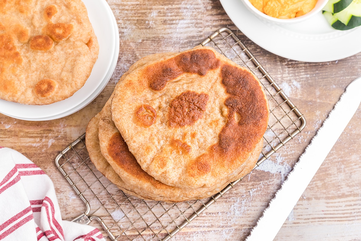 overhead of browned pita bread on a wire rack