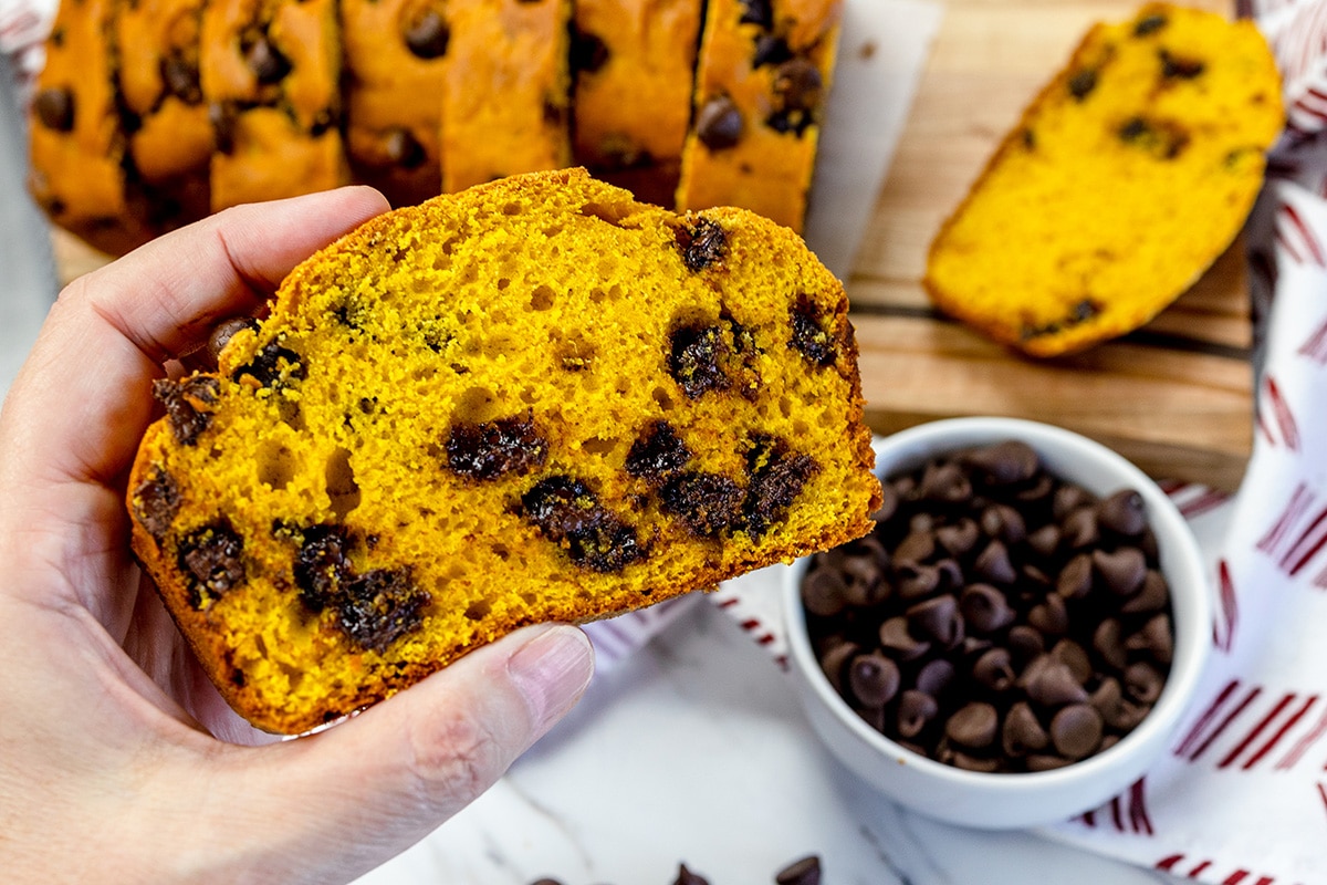 hand holding slice of pumpkin chocolate chip bread