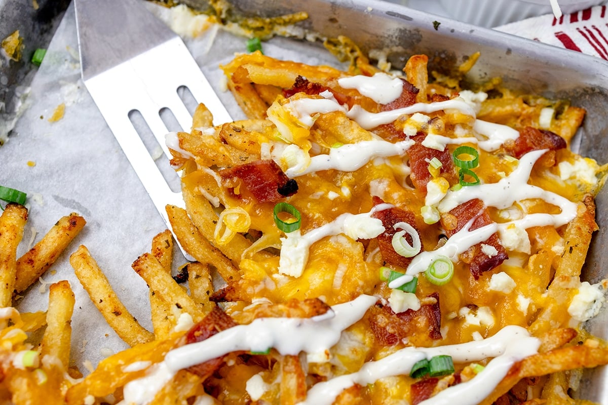 spatula scooping bacon ranch cheese fries