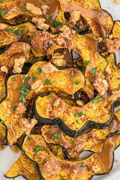 overhead of baked acorn squash with maple sauce and candied walnuts