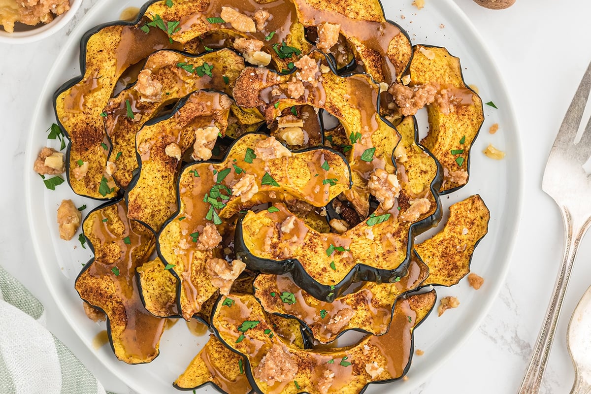 overhead of baked acorn squash with maple sauce and candied walnuts